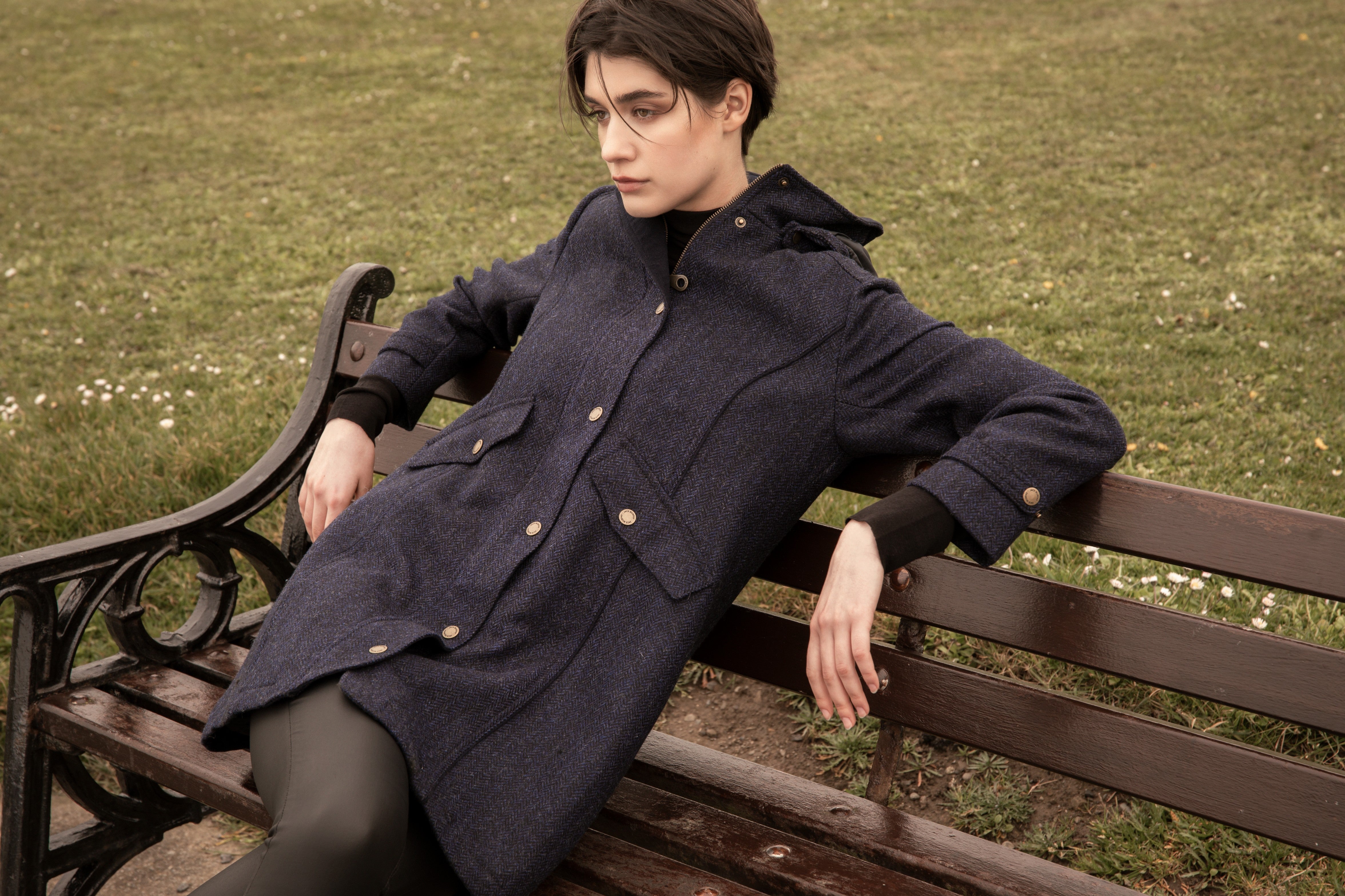 Woman lounging on bench in Abbie Tweed jacket.